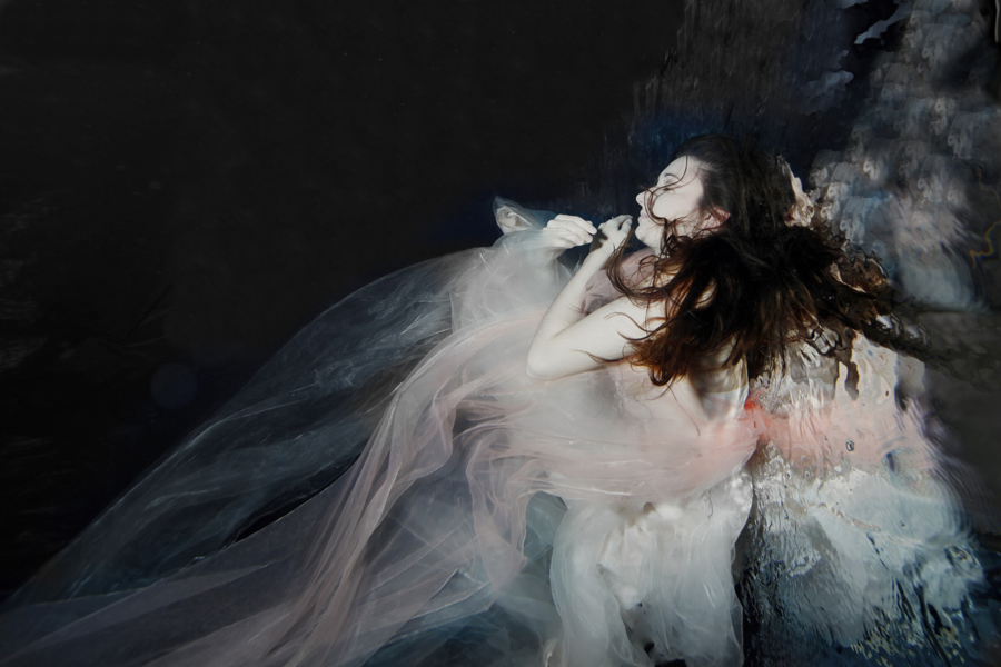 Figure in pale dress amid dark motion