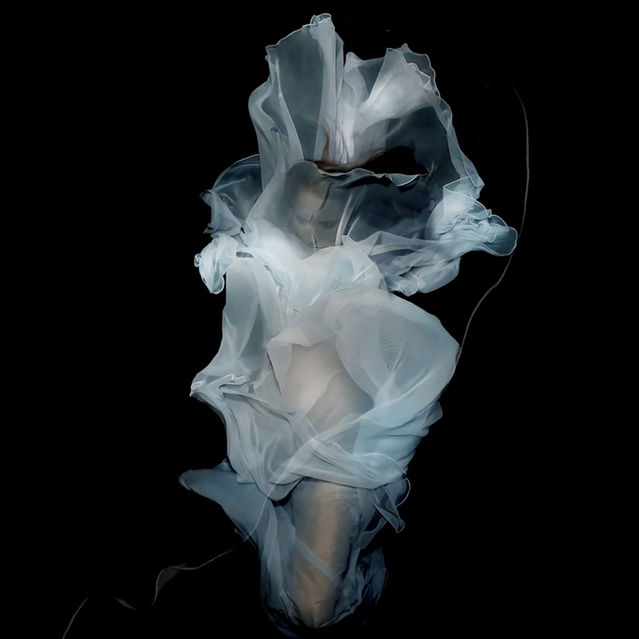 Pale flowing fabric and figure against black