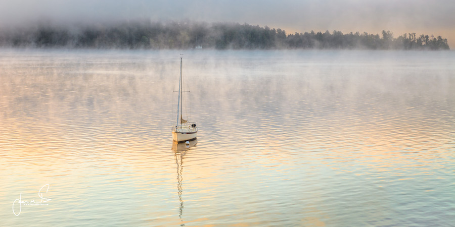 Sailboat in calm water at dawn