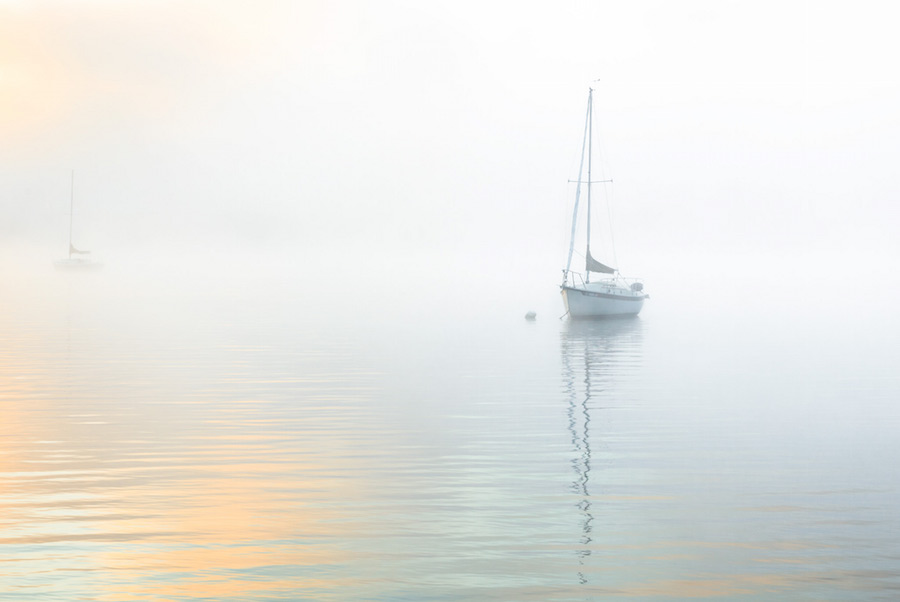Lone boat in pastel morning fog