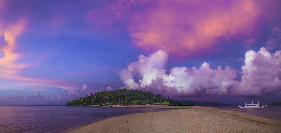 Island beneath clouds in a tropical bay