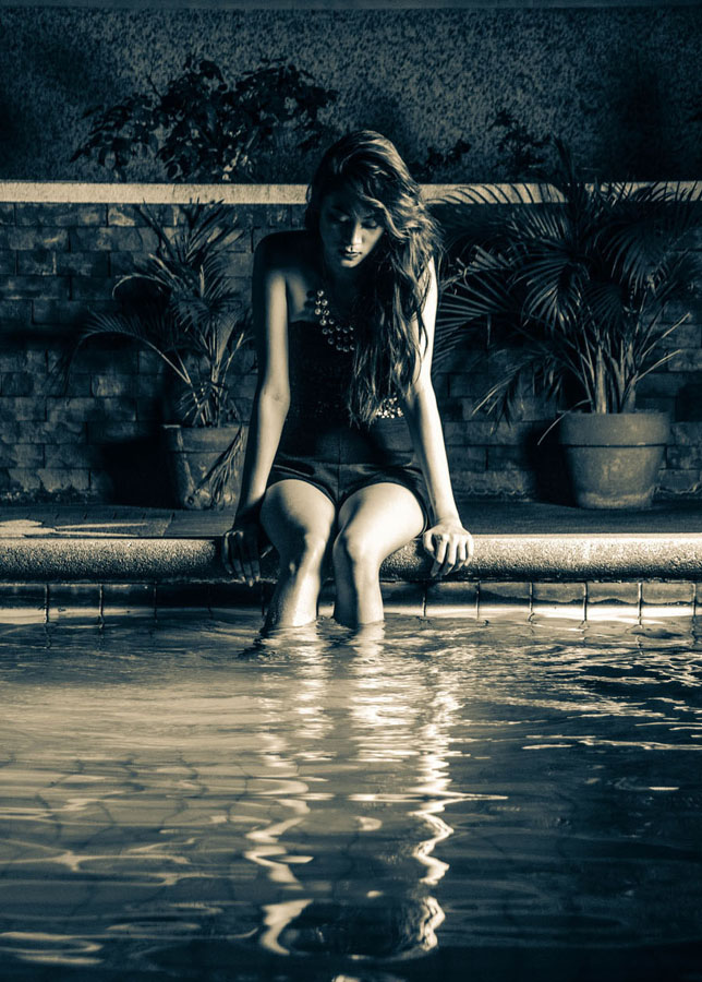 Figure standing near a wall in shallow water
