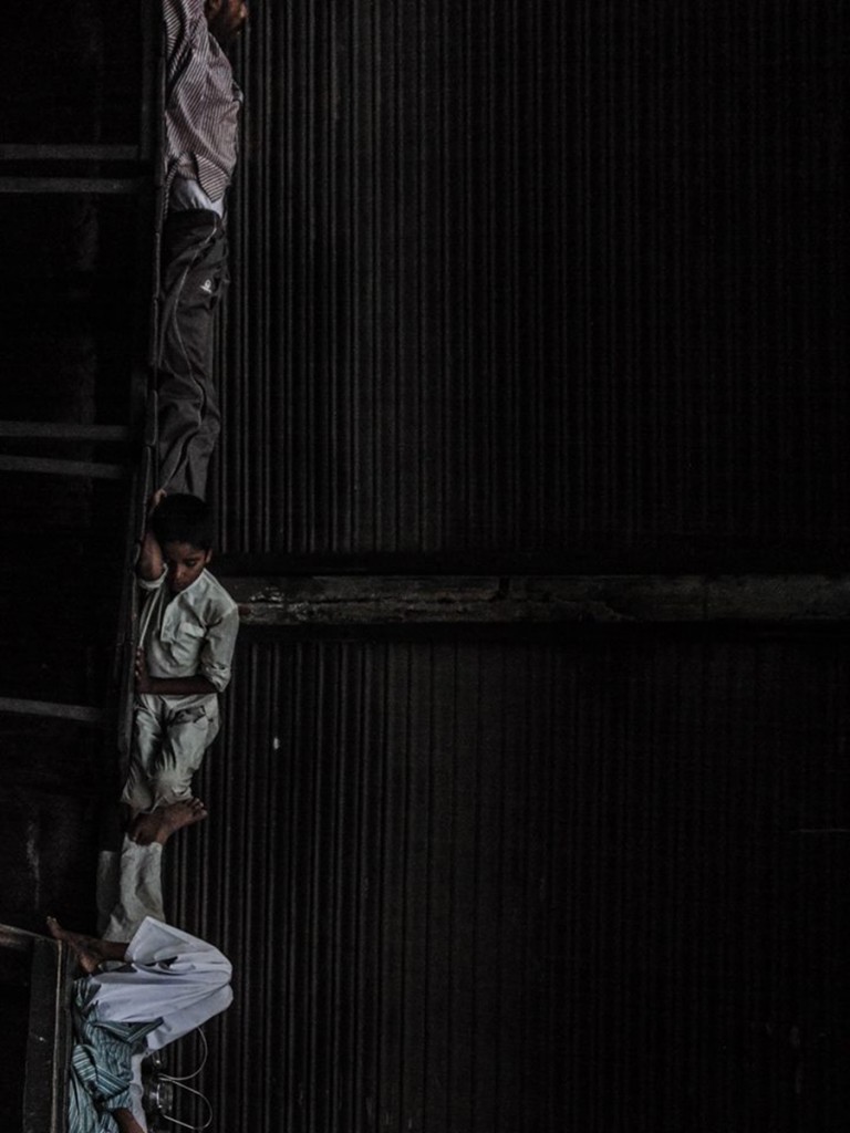 Small figure standing beside dark doorway