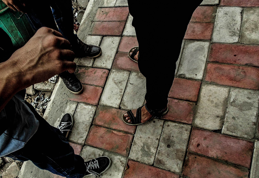 People’s feet on a tiled sidewalk