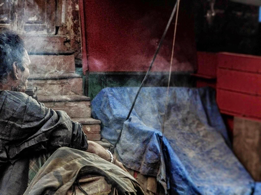 Person sitting near a painted wall