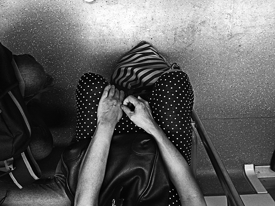 Passenger with head bowed inside a crowded train