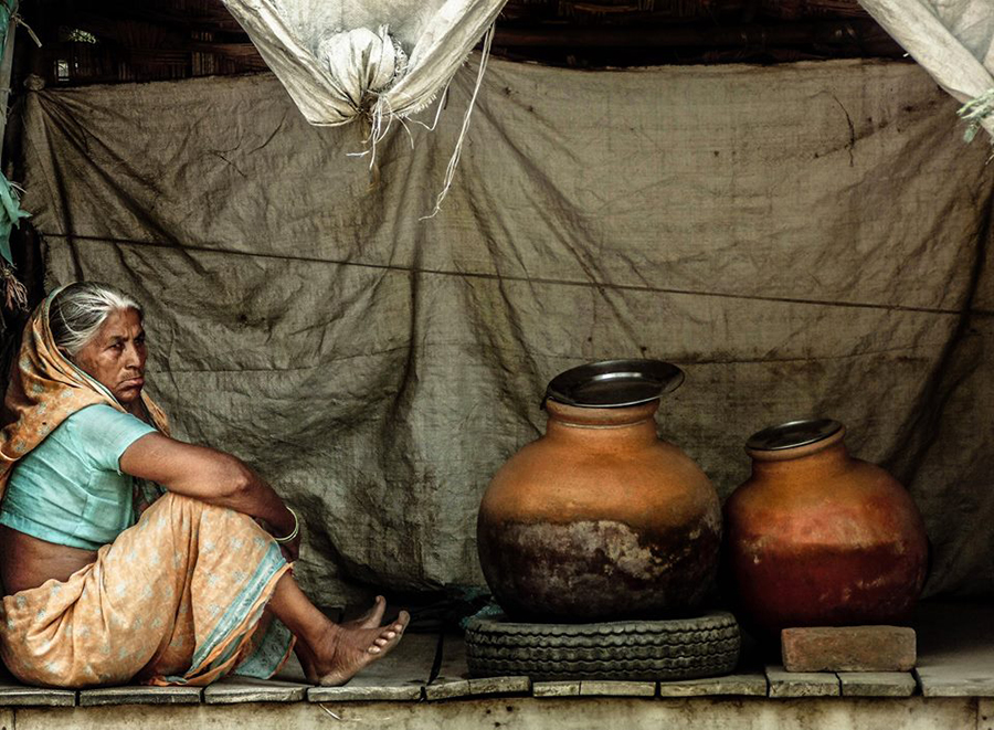 Woman seated beside pottery on a street
