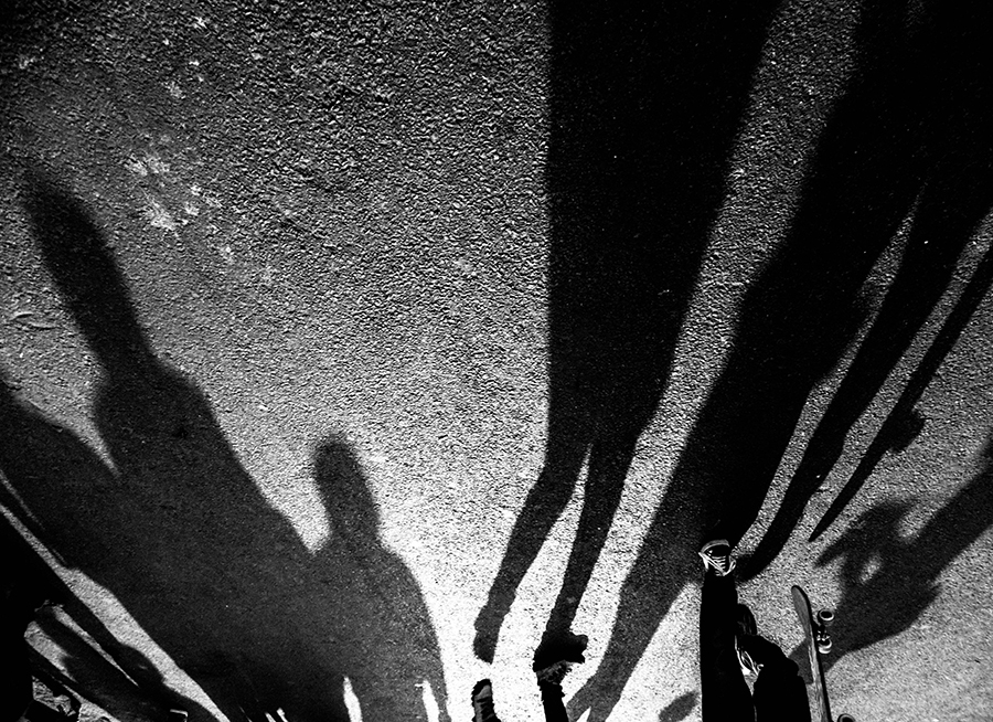 Shadows of pedestrians on pavement