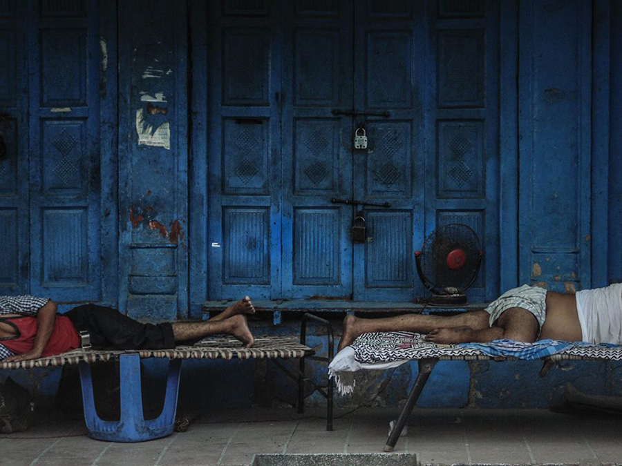 Person reclining beside blue metal doors