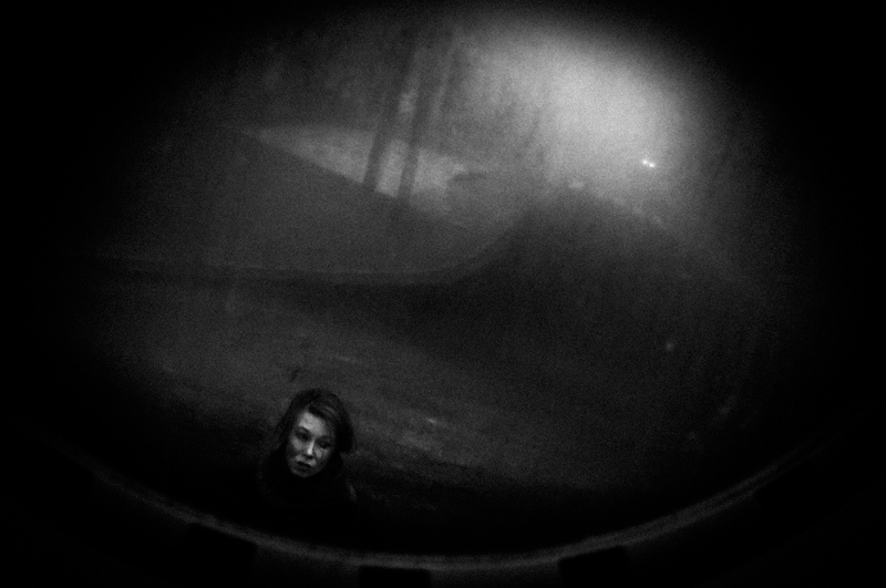 Solitary figure in a dim rounded enclosure