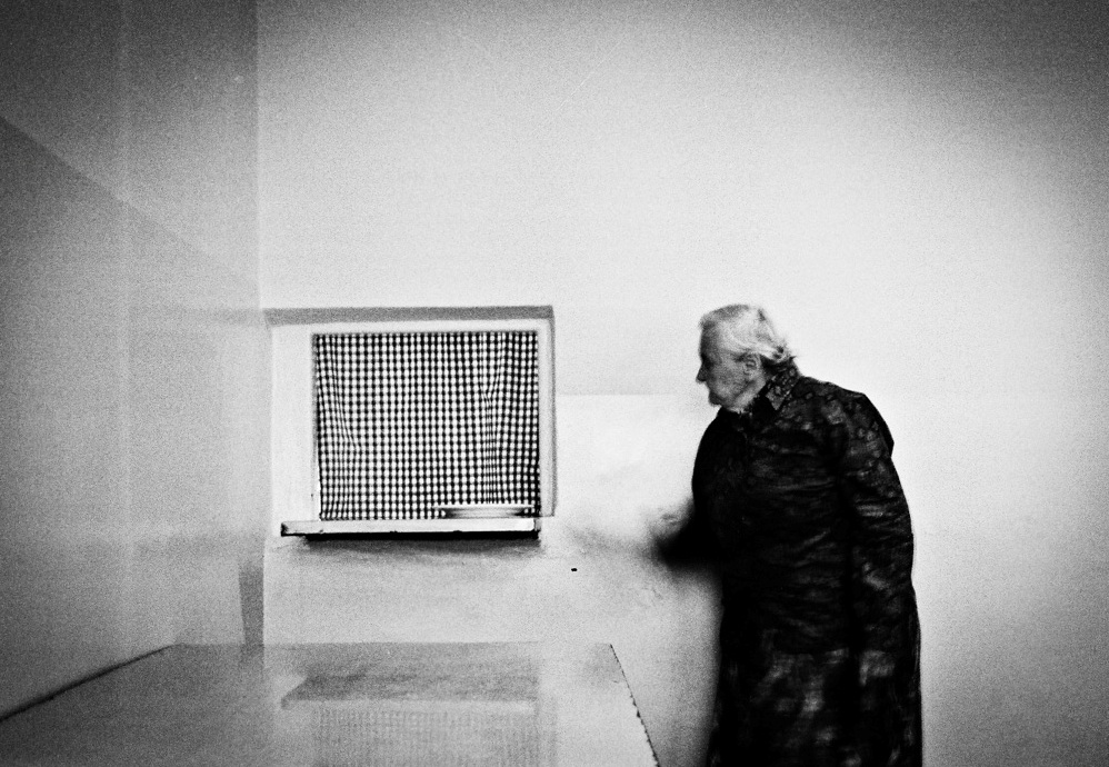 Person standing beside a wall-mounted vent