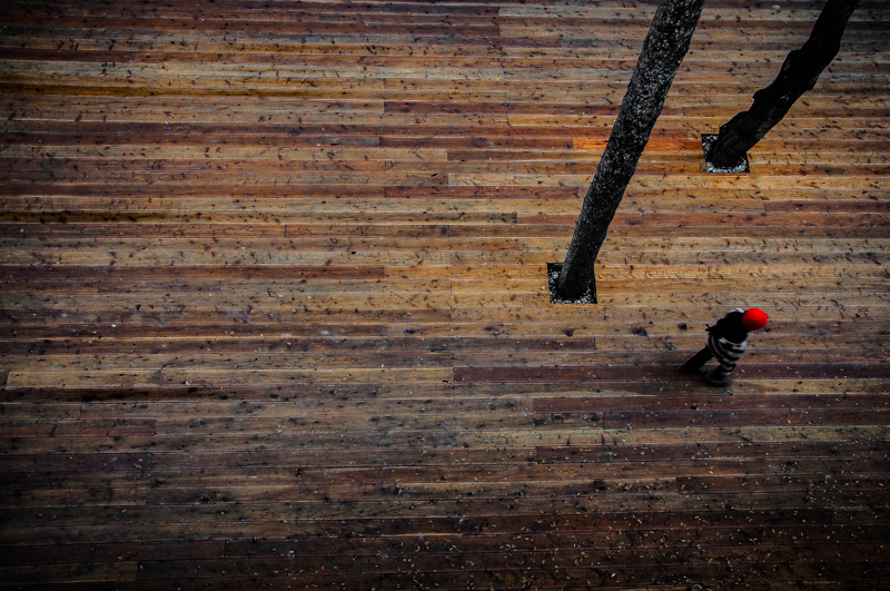 Figure walking along a brick wall
