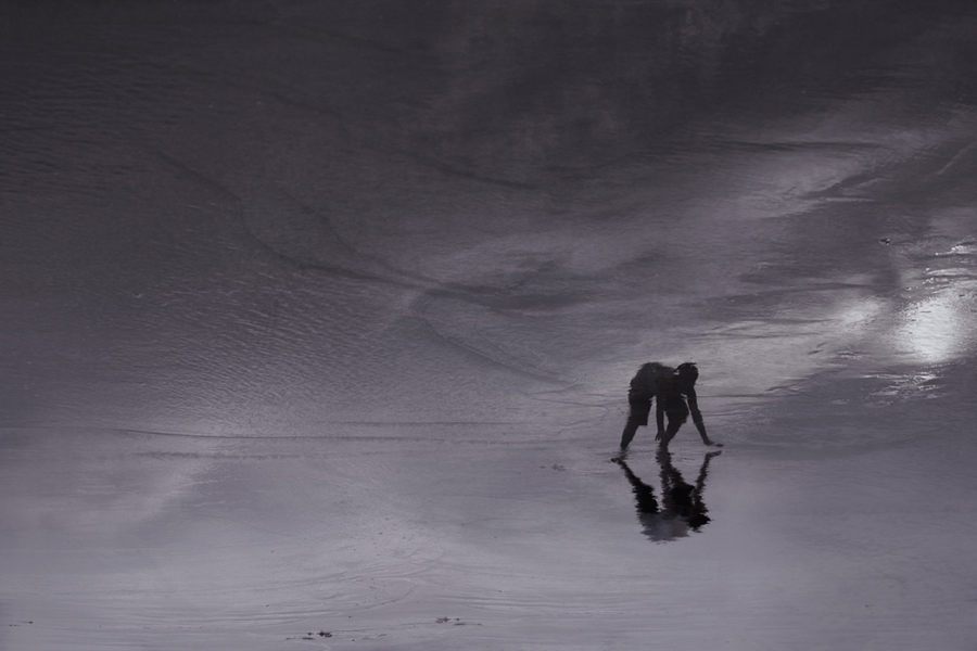 Silhouetted figure leaning toward the sea