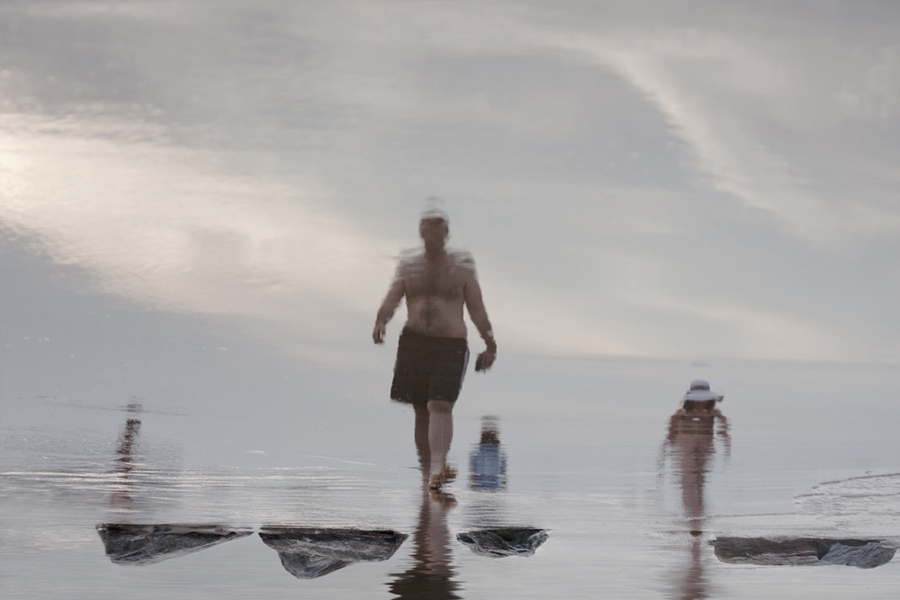 People wading in bright hazy water