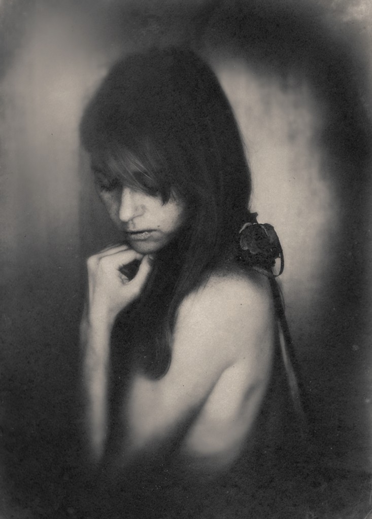 Black-and-white portrait of a woman with head lowered