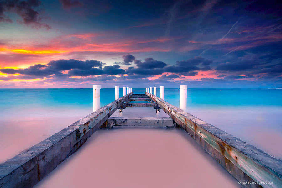 Wooden pier extending into a pastel seascape