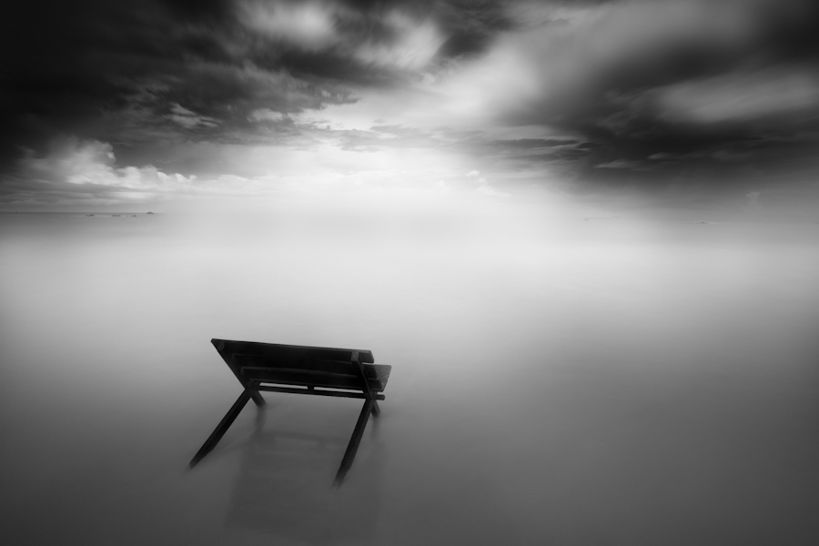Bench half-submerged in still water