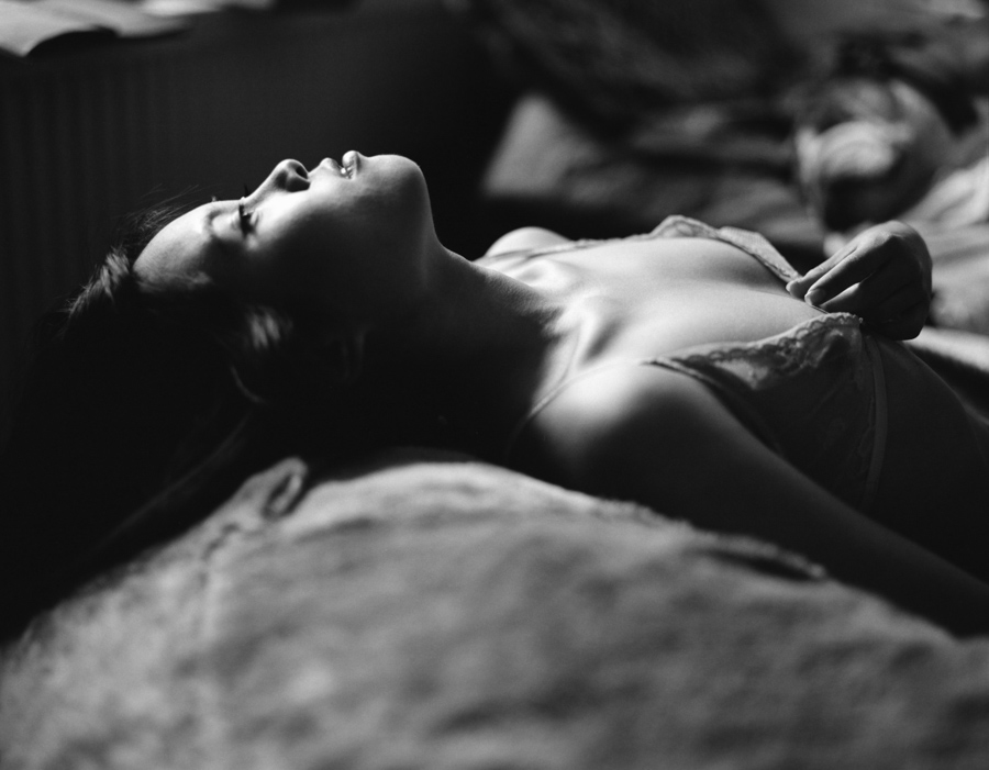 Figure lying on a bed in black and white