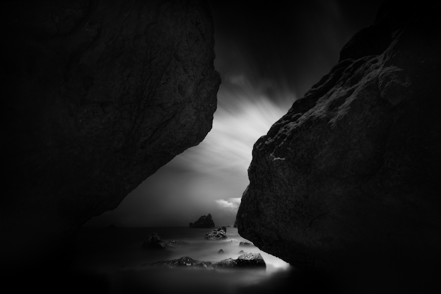 Light entering a narrow rocky gap above water