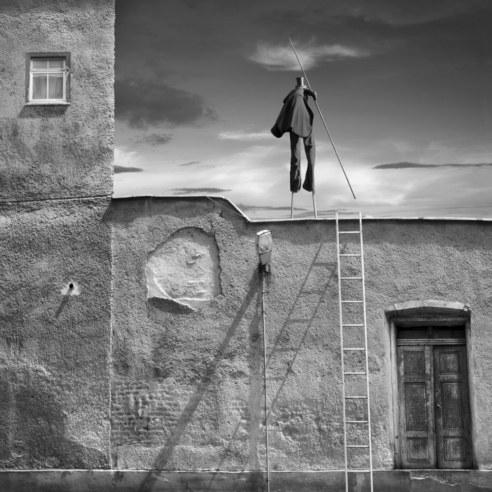 Figure climbing a ladder by an old wall