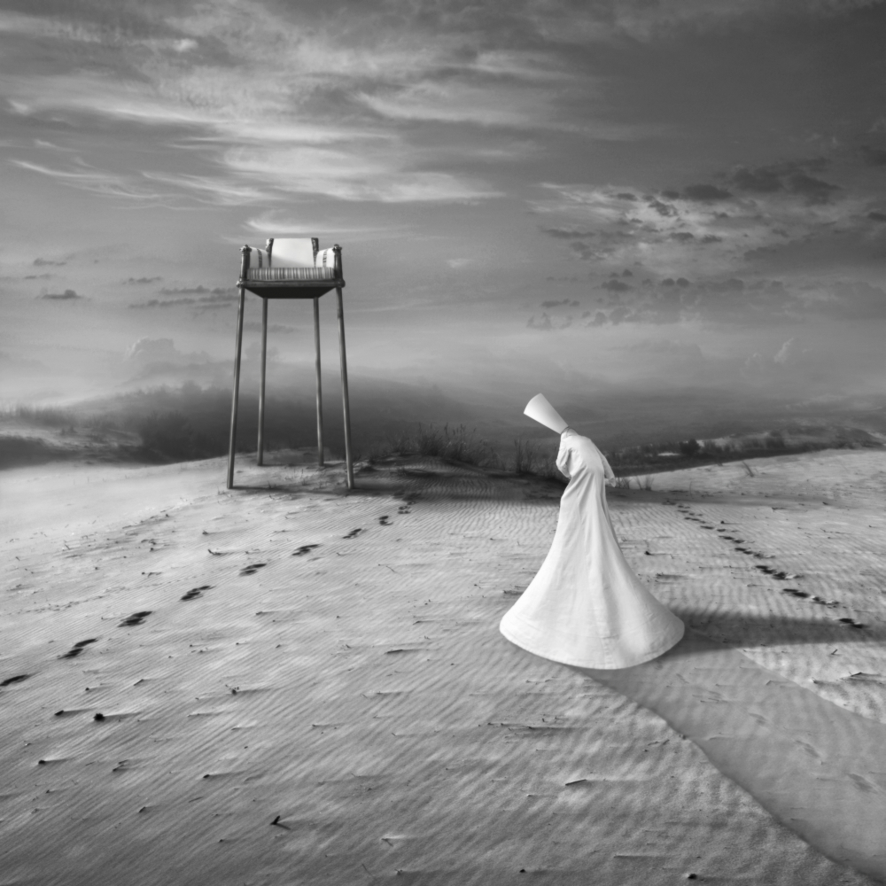 White figure and a chair in a barren landscape