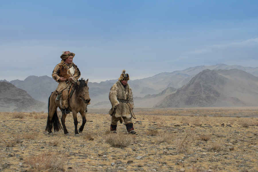 Two riders crossing an open plain