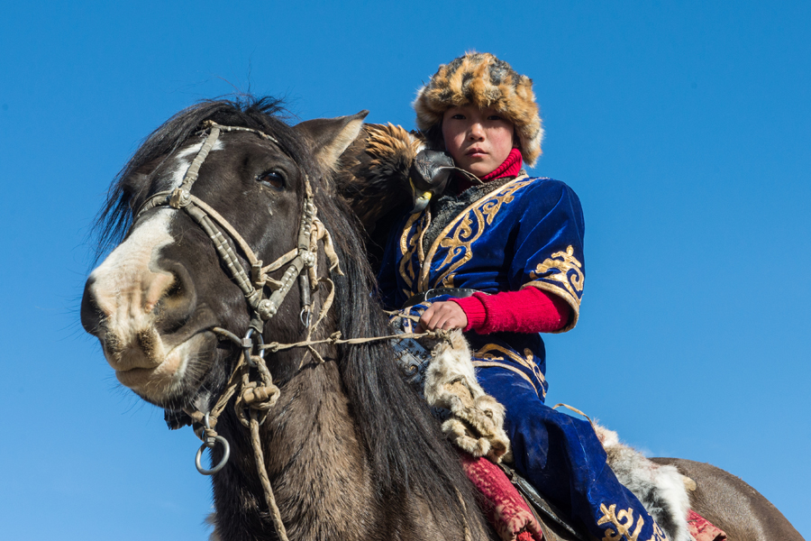 Rider in embroidered clothing beside a horse