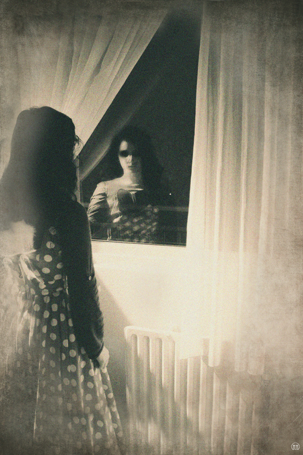 Dark figure beside a bathroom mirror