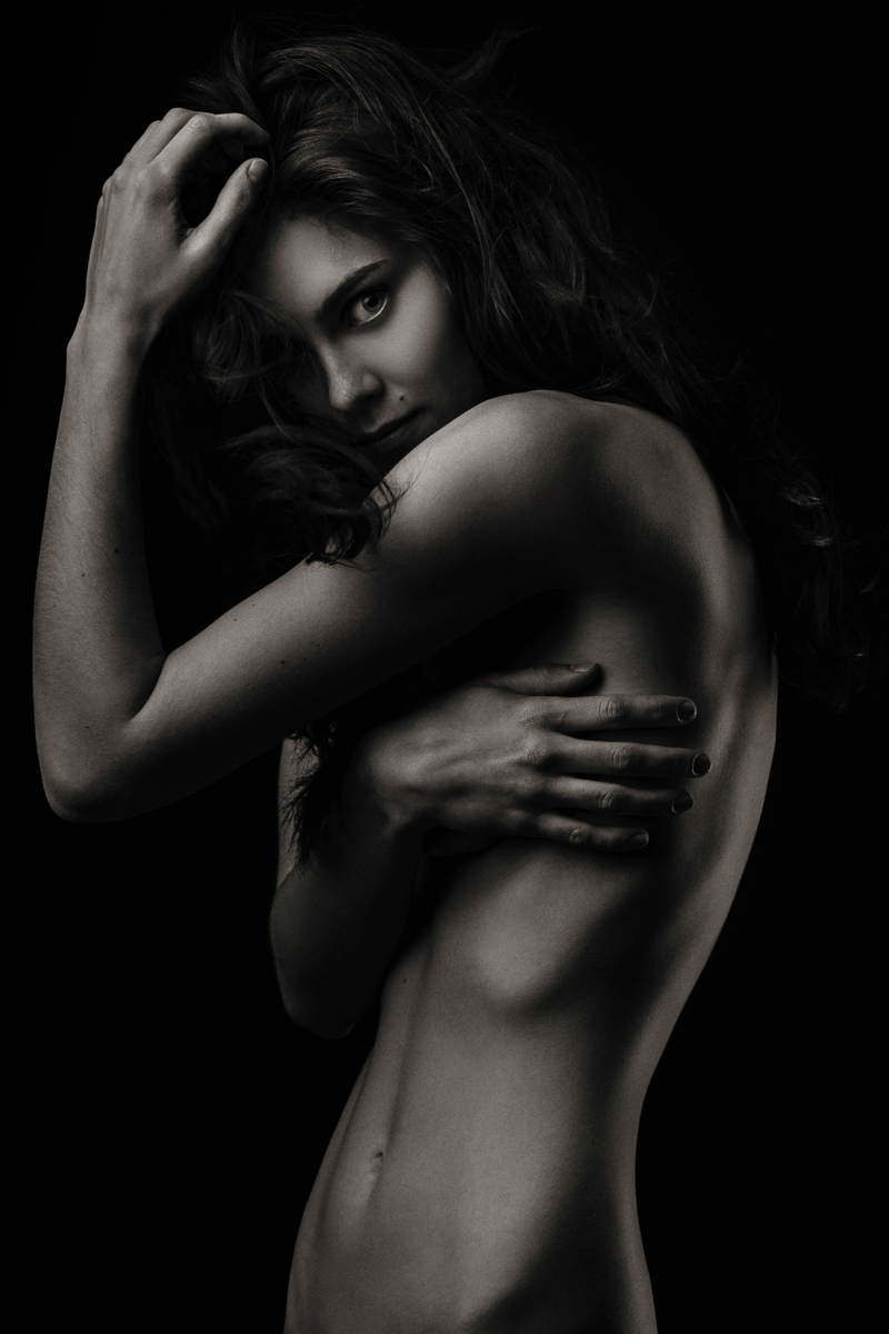Low-key portrait of a woman with folded arms