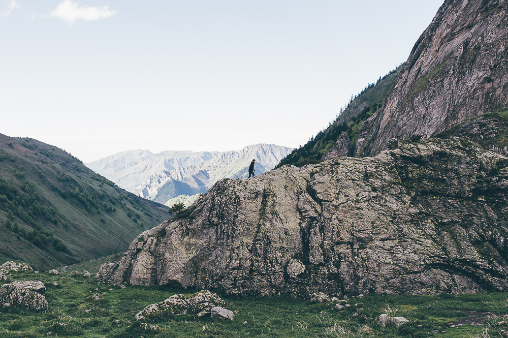 Rocky mountain valley with a large textured cliff and distant pale peaks