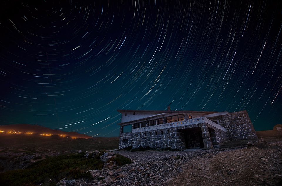 Star trails over a stone building at night - astrophotography by Joao Santos