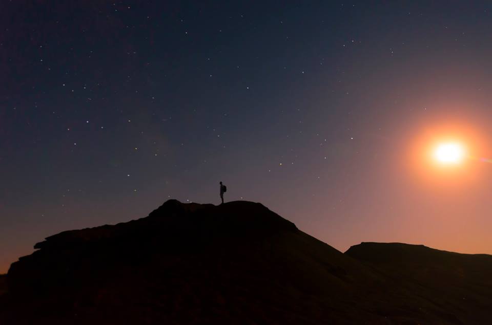 Silhouette on a hilltop under a bright full moon - astrophotography by Joao Santos