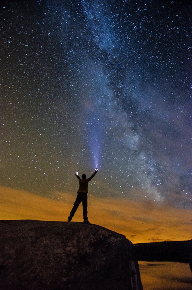 Person with arms raised under the Milky Way - astrophotography by Joao Santos