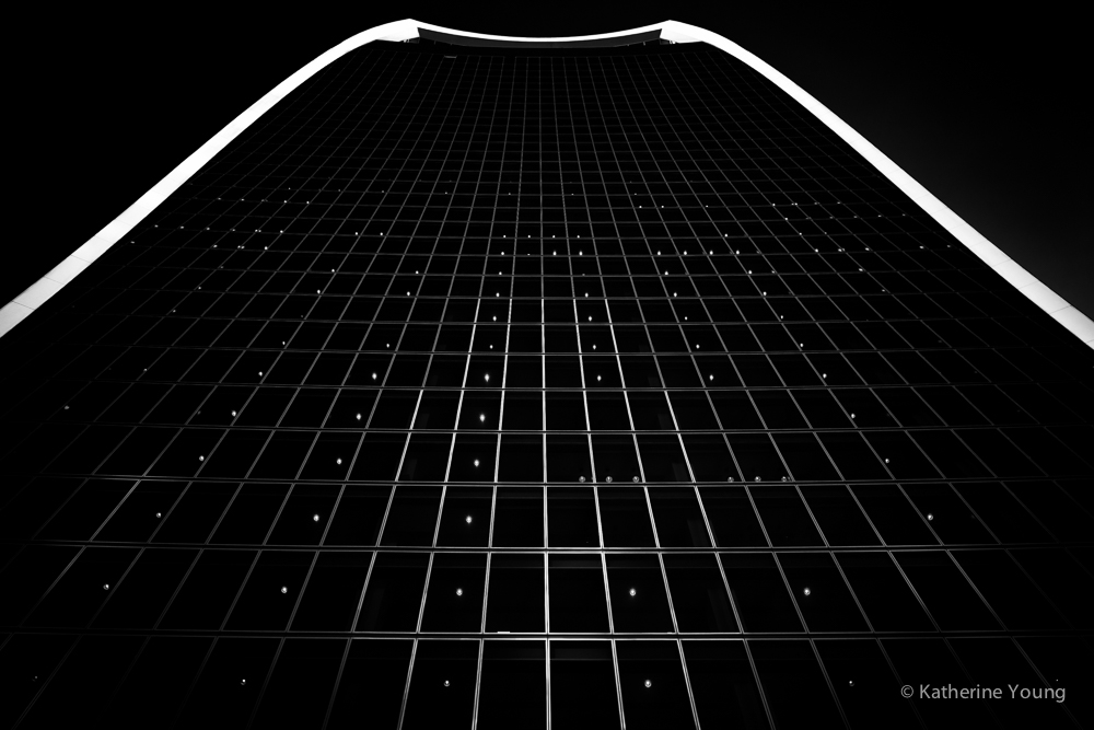 Black and white London building grid beneath a bright curved roof edge