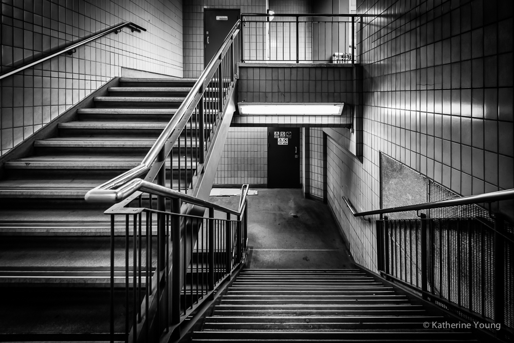 Black and white London stairway with layered handrails and rectangular openings