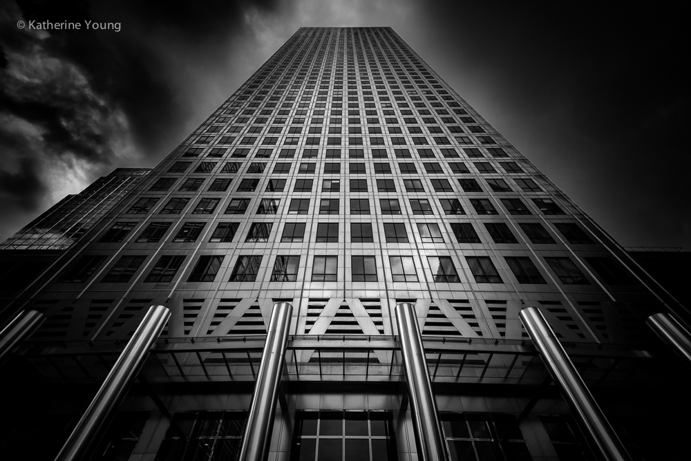 Black and white London tower photographed upward with converging window lines