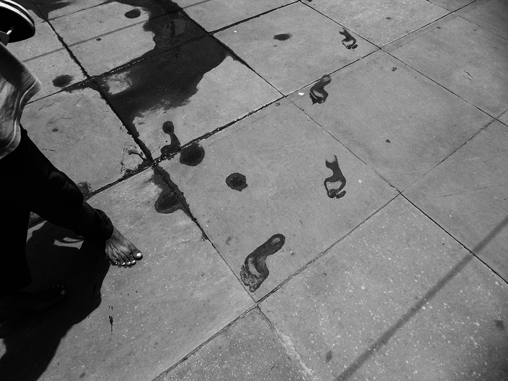 Wet footprints and bare feet on pavement, Delhi - Life by Devashish Gaur