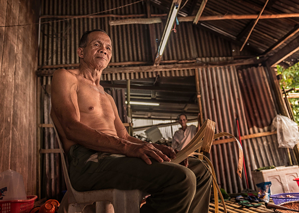 Elderly Bidayuh man inside a bamboo longhouse - The Native of Sarawak by Edanan Taiban