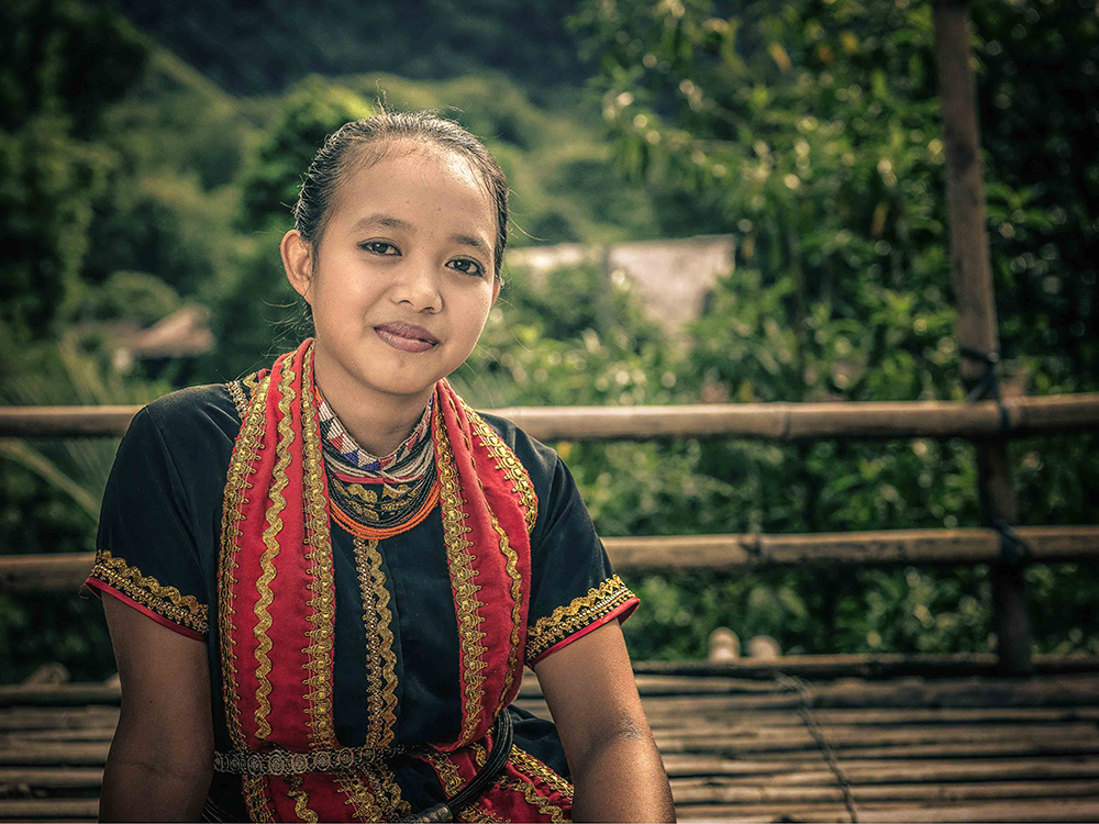 Young Bidayuh woman in traditional beads on a bamboo bridge - The Native of Sarawak by Edanan Taiban