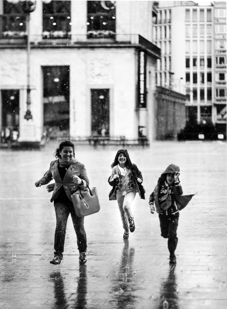 Three women hurrying through the rain - Rain by Marco Gaia