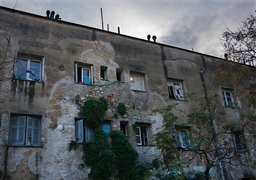 Weathered apartment block housing refugees, Athens - The Unblinking Eyes by Nensi Bogdani