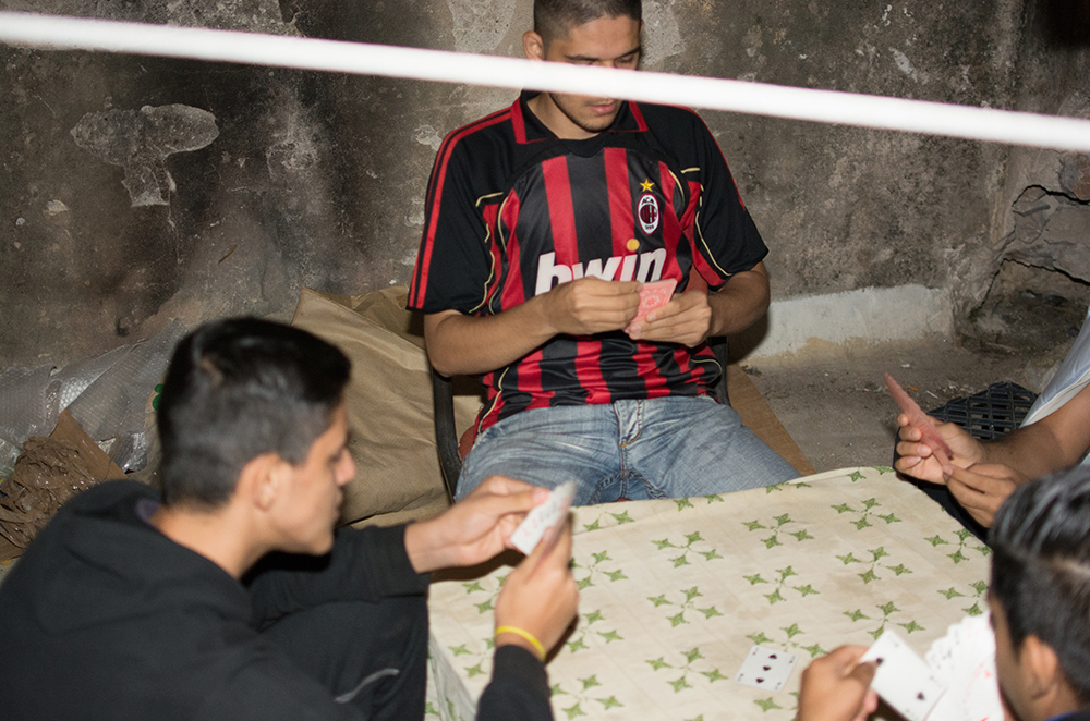 Refugee men talking around a table in an Athens squat - The Unblinking Eyes by Nensi Bogdani