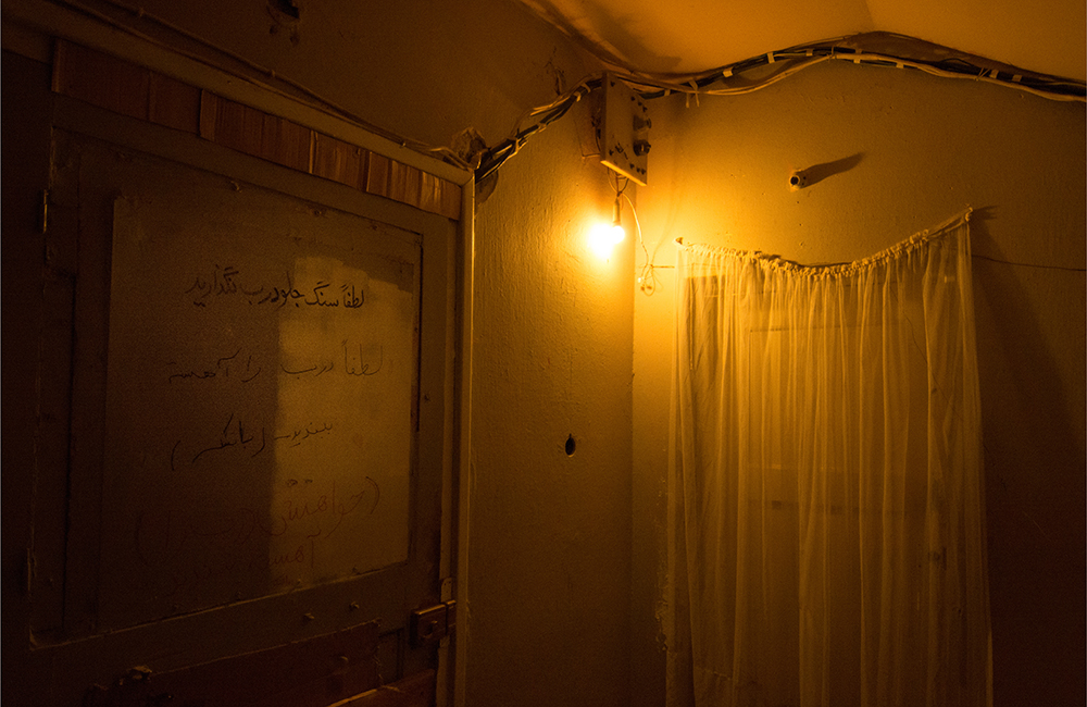 Lamp-lit hallway in an Athens squat - The Unblinking Eyes by Nensi Bogdani