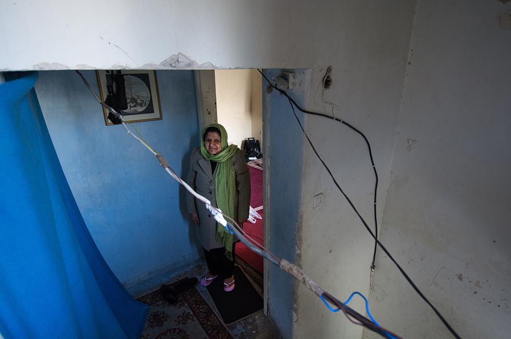 Boy standing in a blue doorway - The Unblinking Eyes by Nensi Bogdani