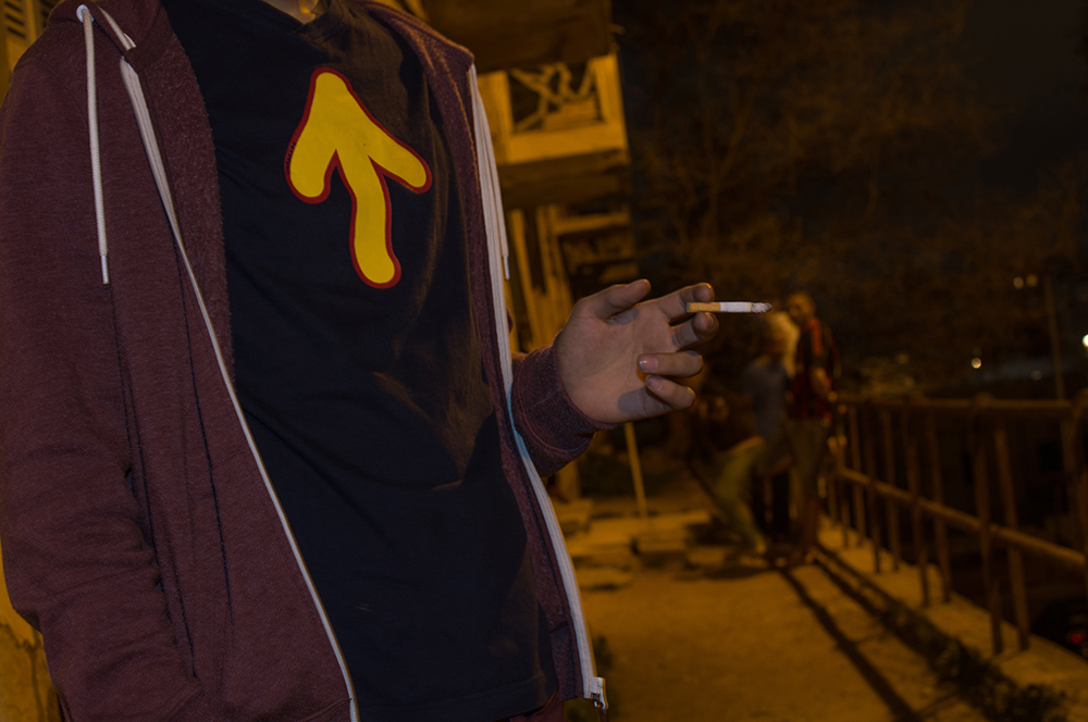 Man pointing on an Athens street at night - The Unblinking Eyes by Nensi Bogdani