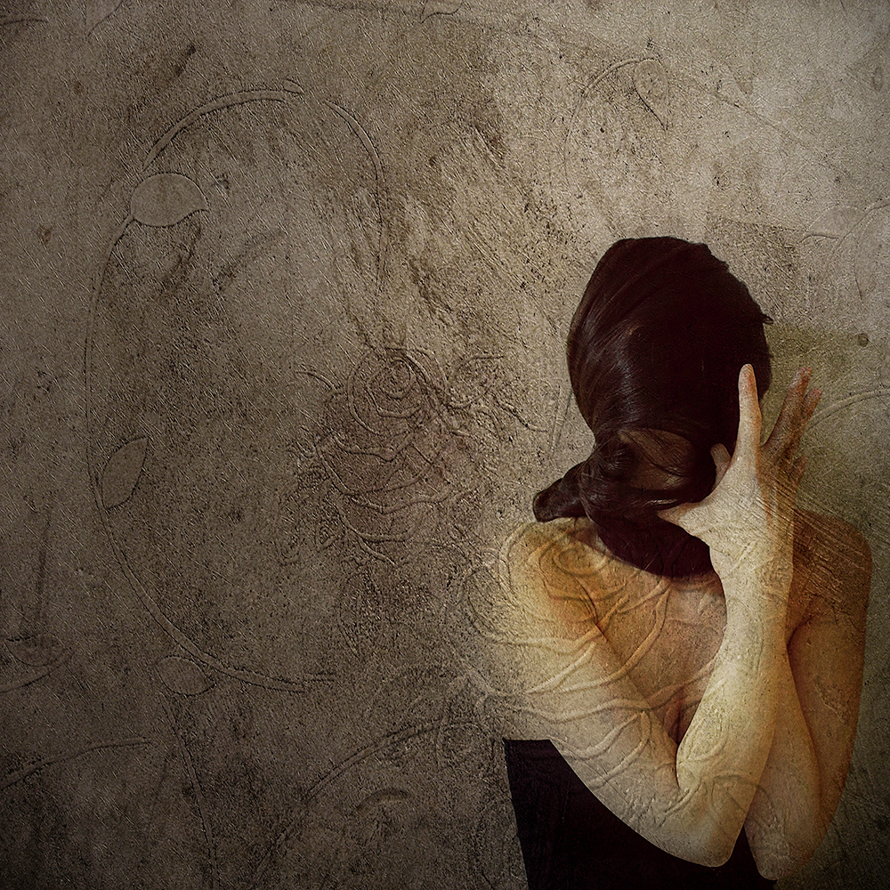 Woman holding her long braid against a textured wall - surreal photo by Cathryn Mok