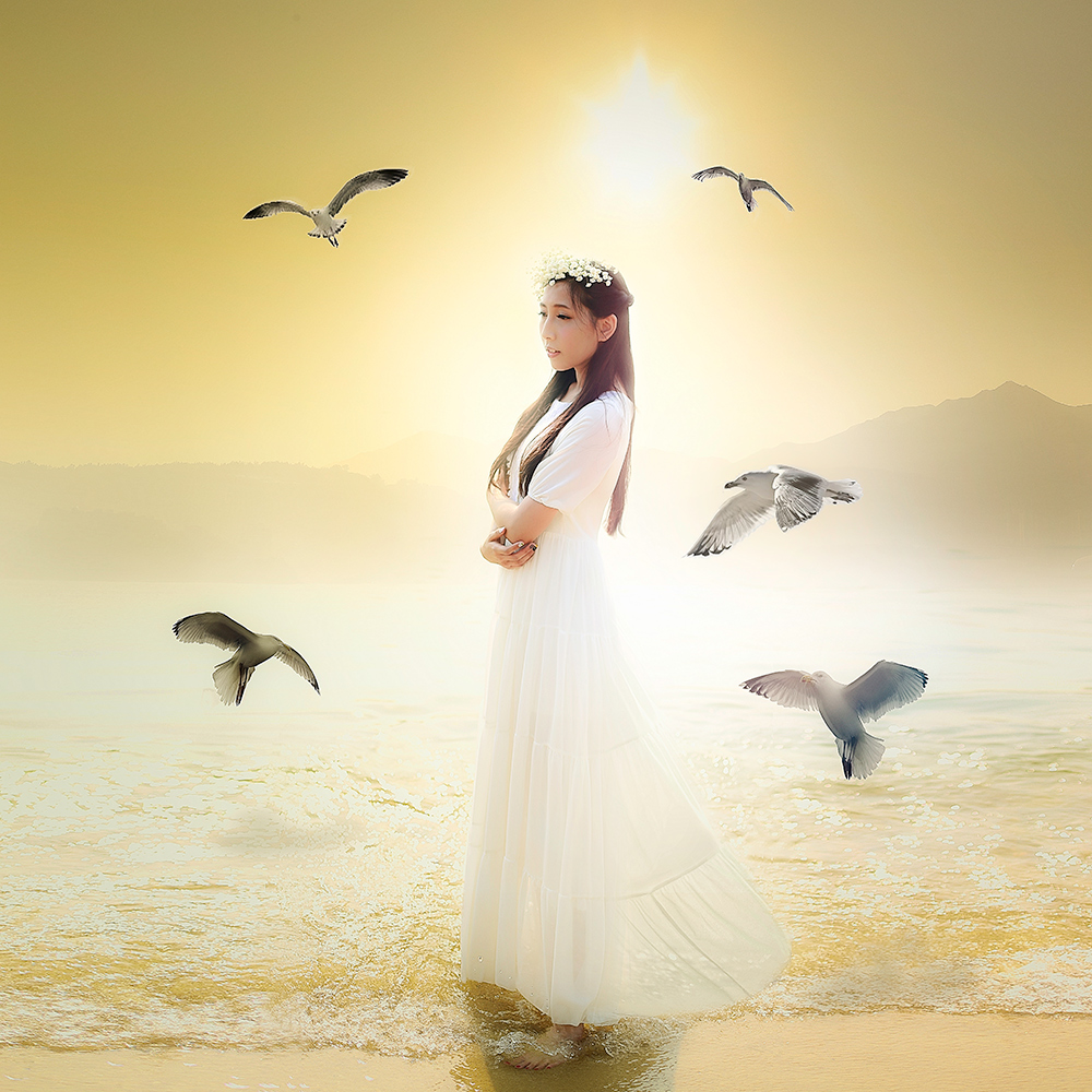Woman in a white dress by the sea with birds - surreal photo by Cathryn Mok