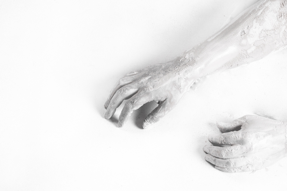 Porcelain-covered arms and hands resting on white - Fading away, depression series by Cheree Smith
