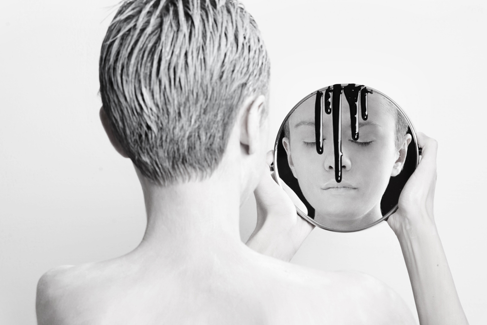 Figure holding a mirror with dripping black paint - Metamorphosis Black Butterfly by Olga Volodina