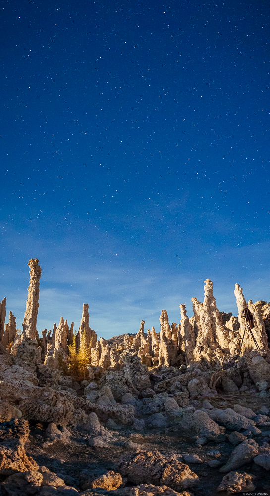 Tall mineral formations in a narrow vertical landscape beneath a deep blue sky